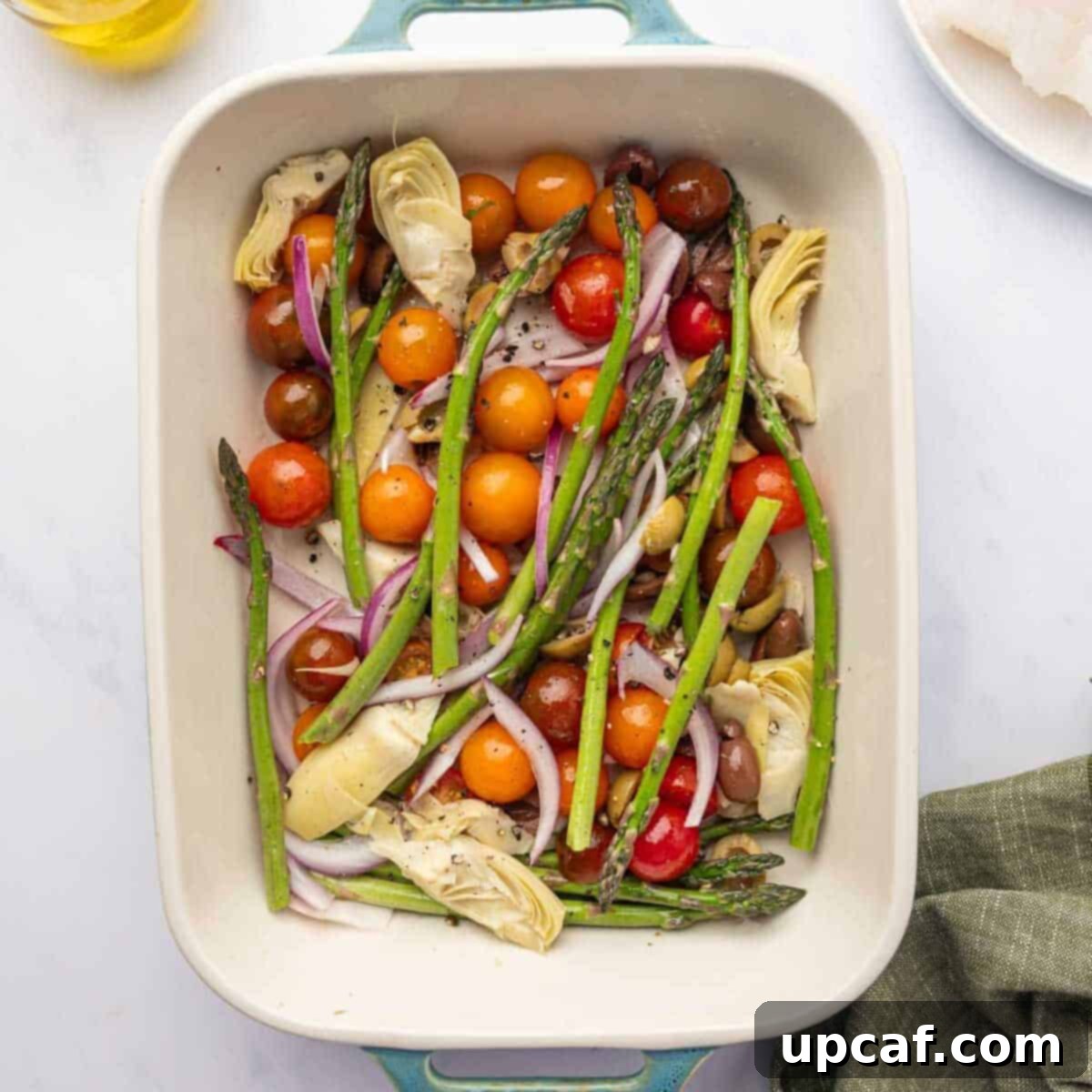 Vegetables are layered in a baking dish.