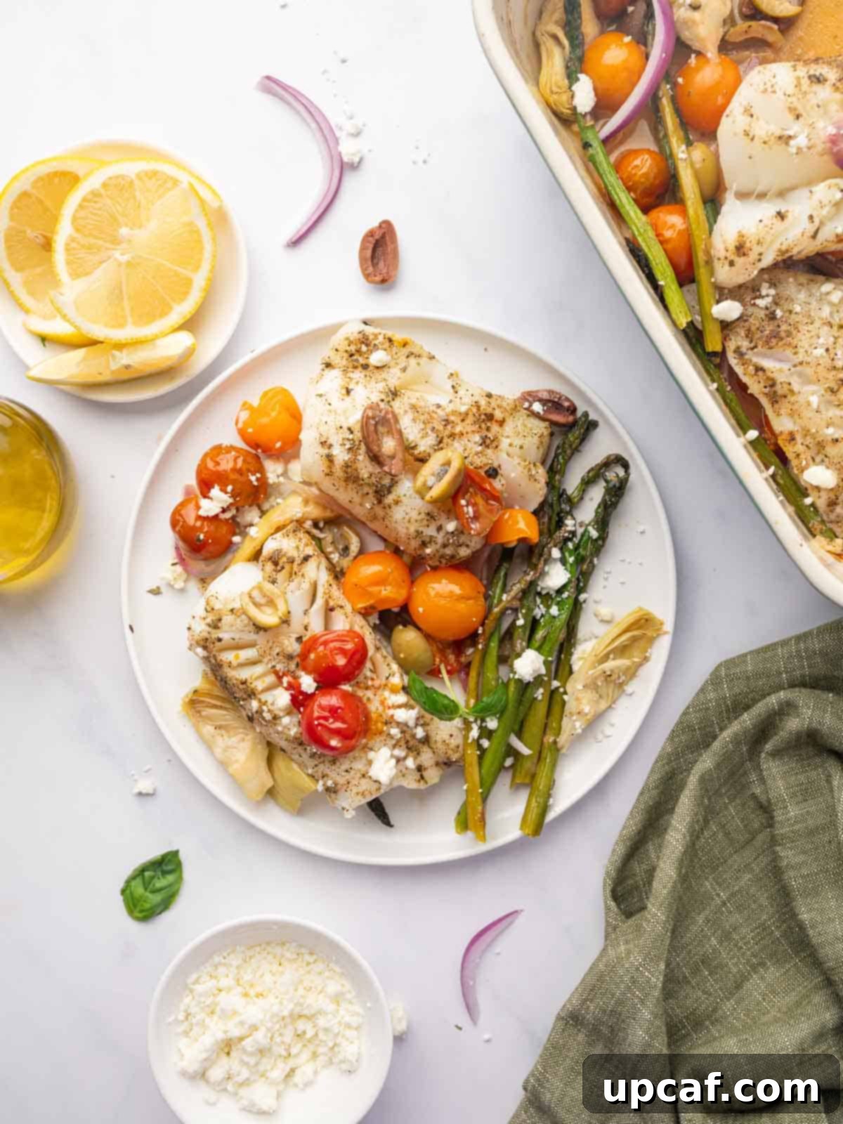 A plate of mediterranean cod fillets with vegetables.