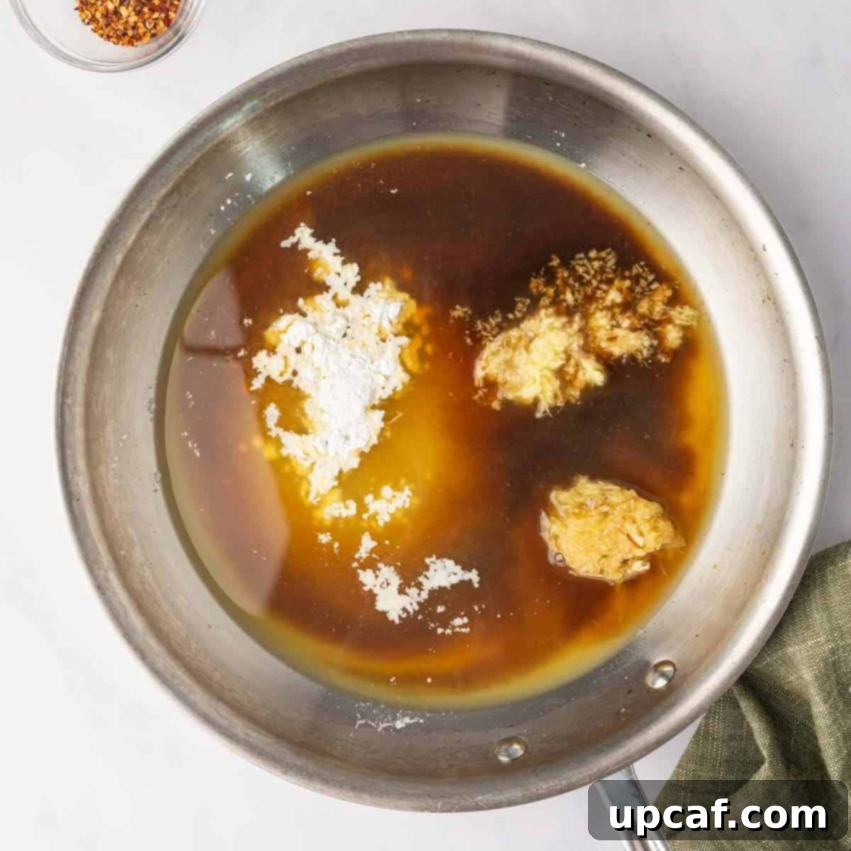 All orange chicken sauce ingredients combined in a small skillet, ready to be heated.