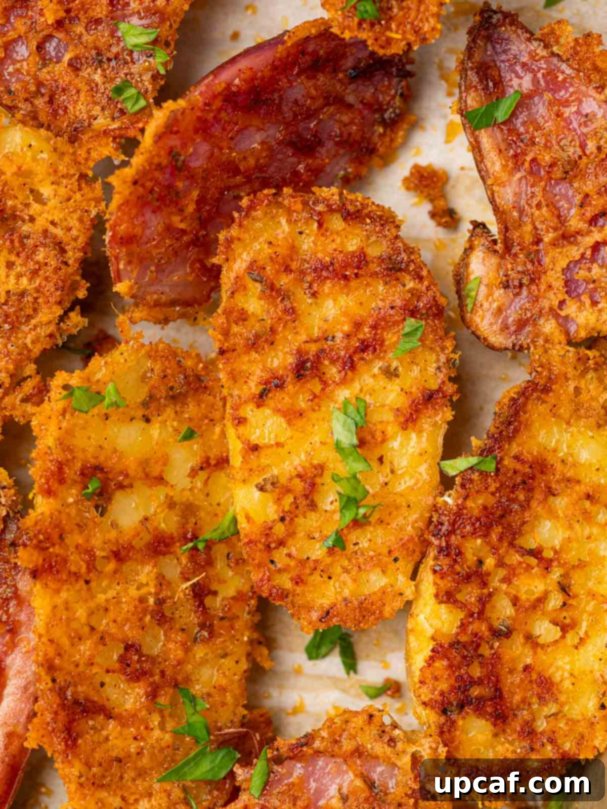 Close up photo of cheesy crusted fingerling potatoes garnished with parsley.