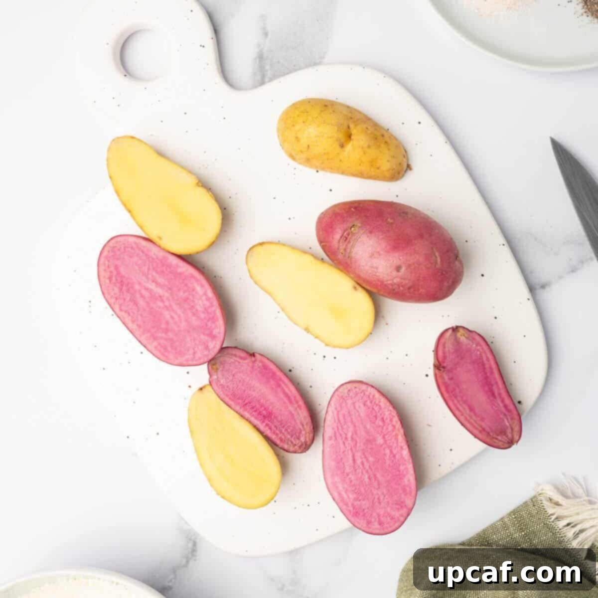 Fingerling potatoes are sliced in half.