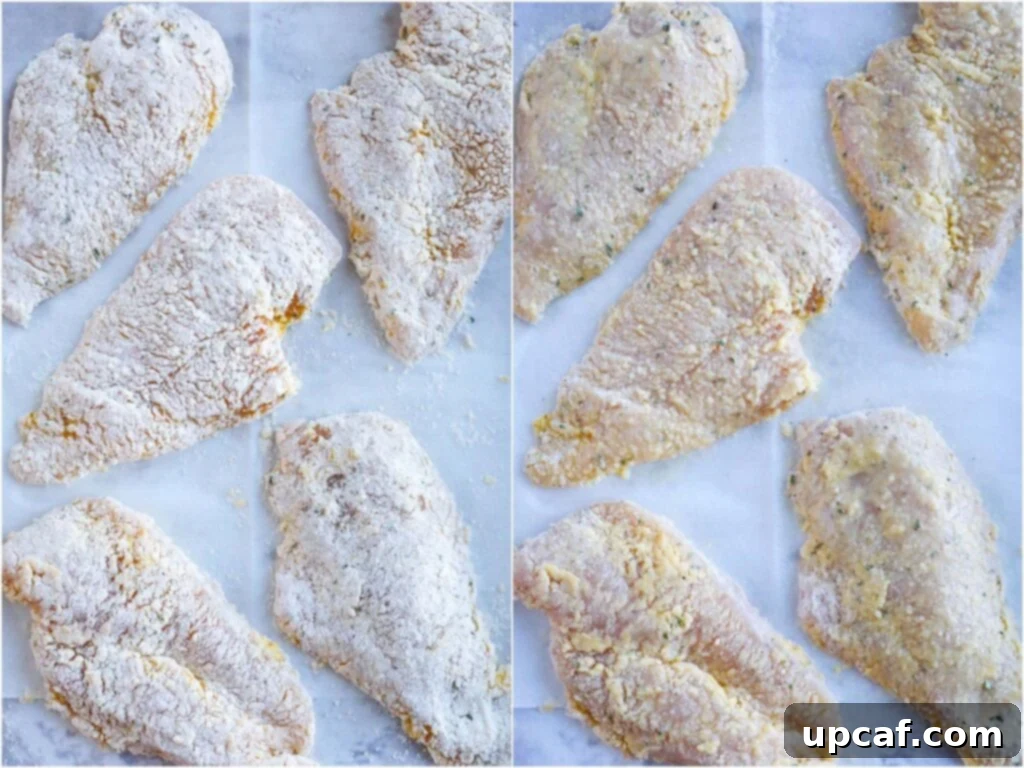 Parmesan Coated Chicken Raw chicken breasts fully coated in a seasoned breading mixture, ready for baking on a parchment-lined tray.