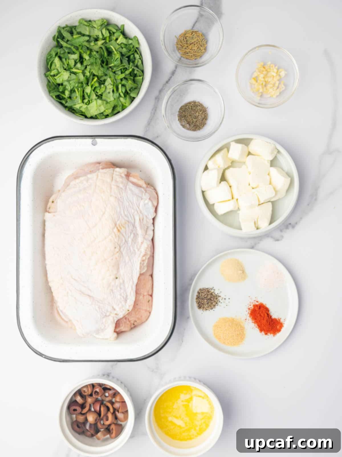 Savory Stuffed Turkey Roll 3 A collection of fresh and dried ingredients are neatly arranged on a white surface, showcasing all that is needed to make a delicious stuffed turkey roll.