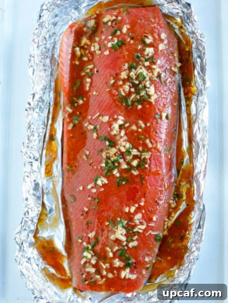 Overhead shot of marinated salmon fillet in foil, ready to bake