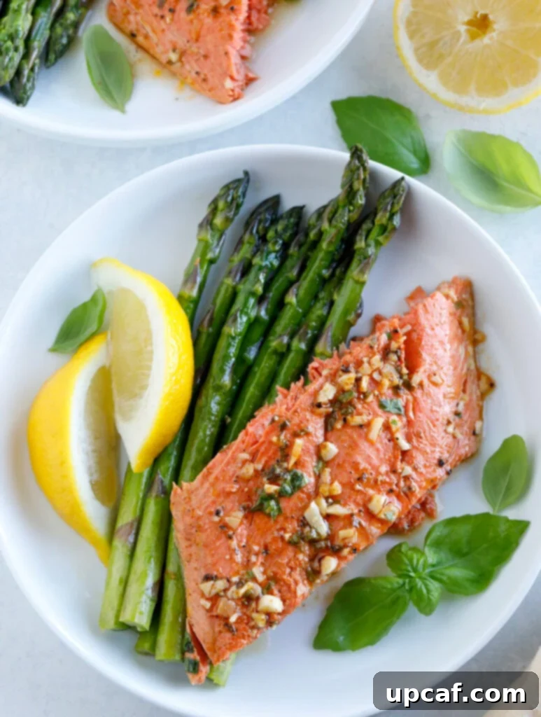 Baked Honey Garlic Salmon with asparagus and lemon on a white plate