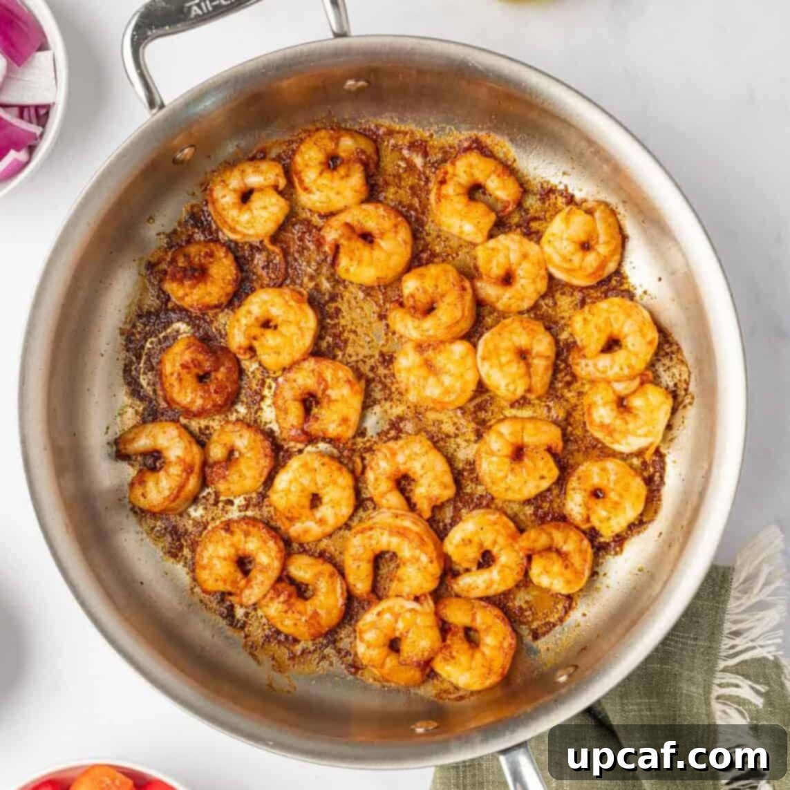 Sauteed shrimp in a skillet.