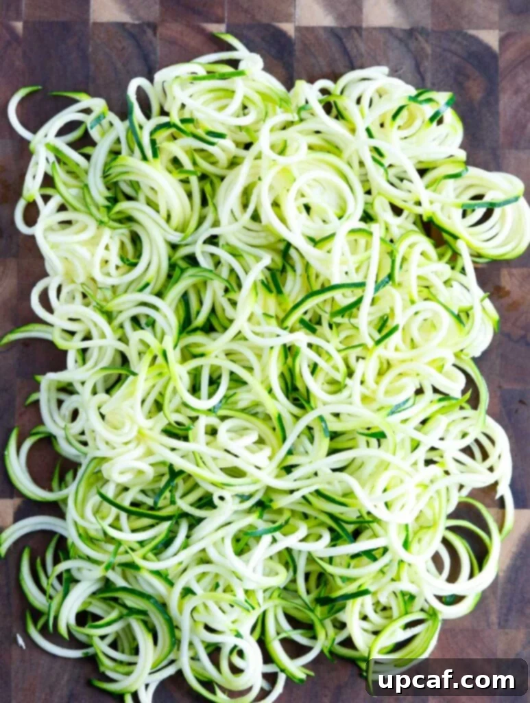 Zucchini noodles ready for cooking Freshly spiralized zucchini noodles (zoodles) on a cutting board