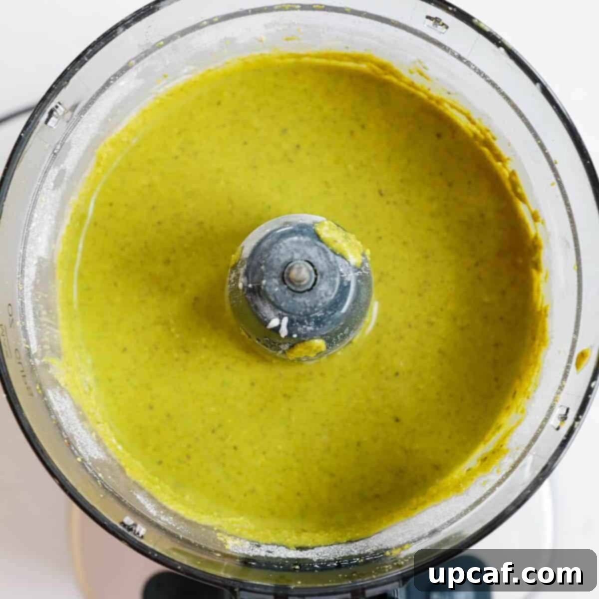 Velvety Pistachio Cream 7 Finished smooth homemade pistachio cream in a food processor, ready to be transferred.