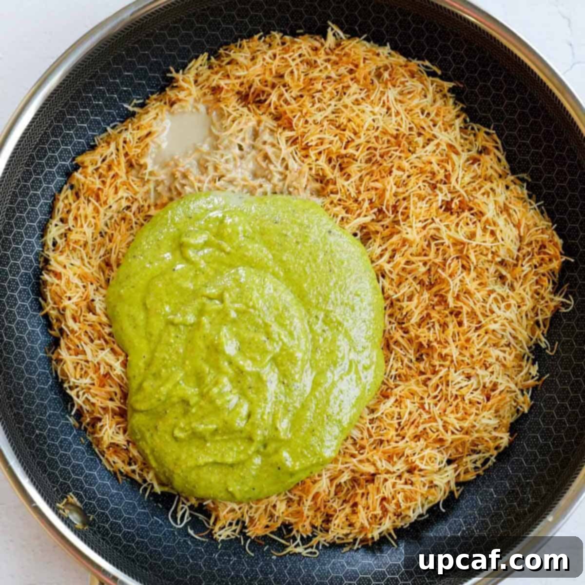 Adding pistachio and tahini to the toasted kataifi crip.