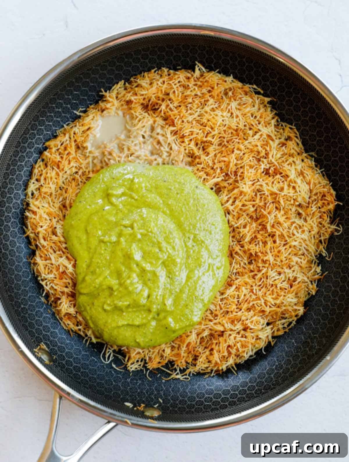 Adding pistachio and tahini to the toasted kataifi crisp.