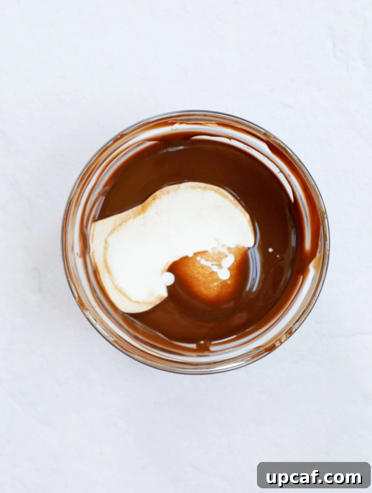 Melted Chocolate with heavy cream in a cup to make chocolate ganache.