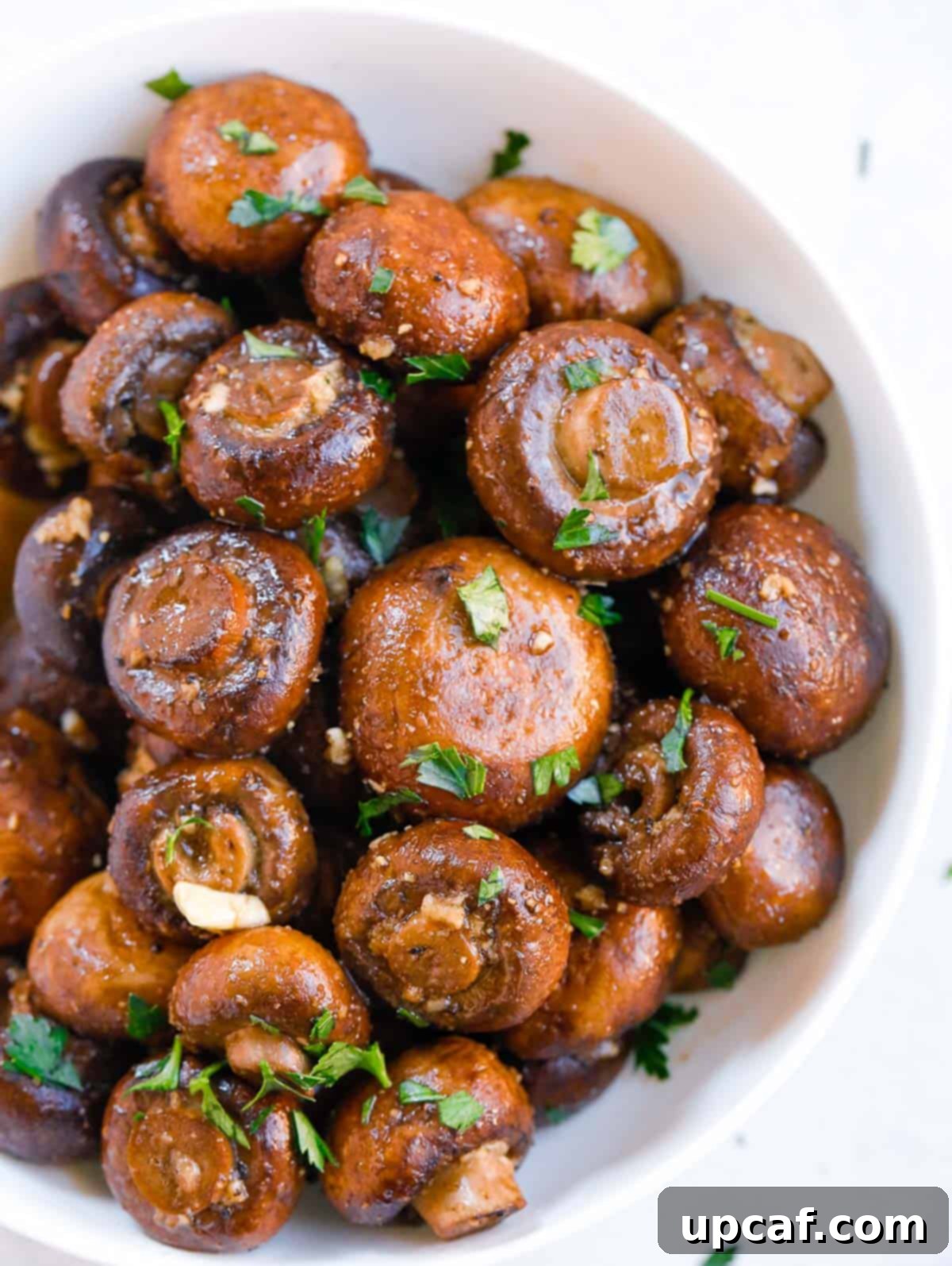 A bowl of perfectly roasted garlic butter mushrooms, ready to be served.