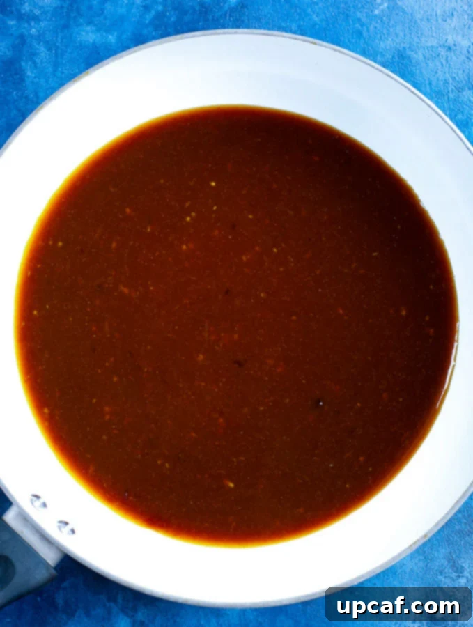 orange chicken sauce cooked in a white skillet.