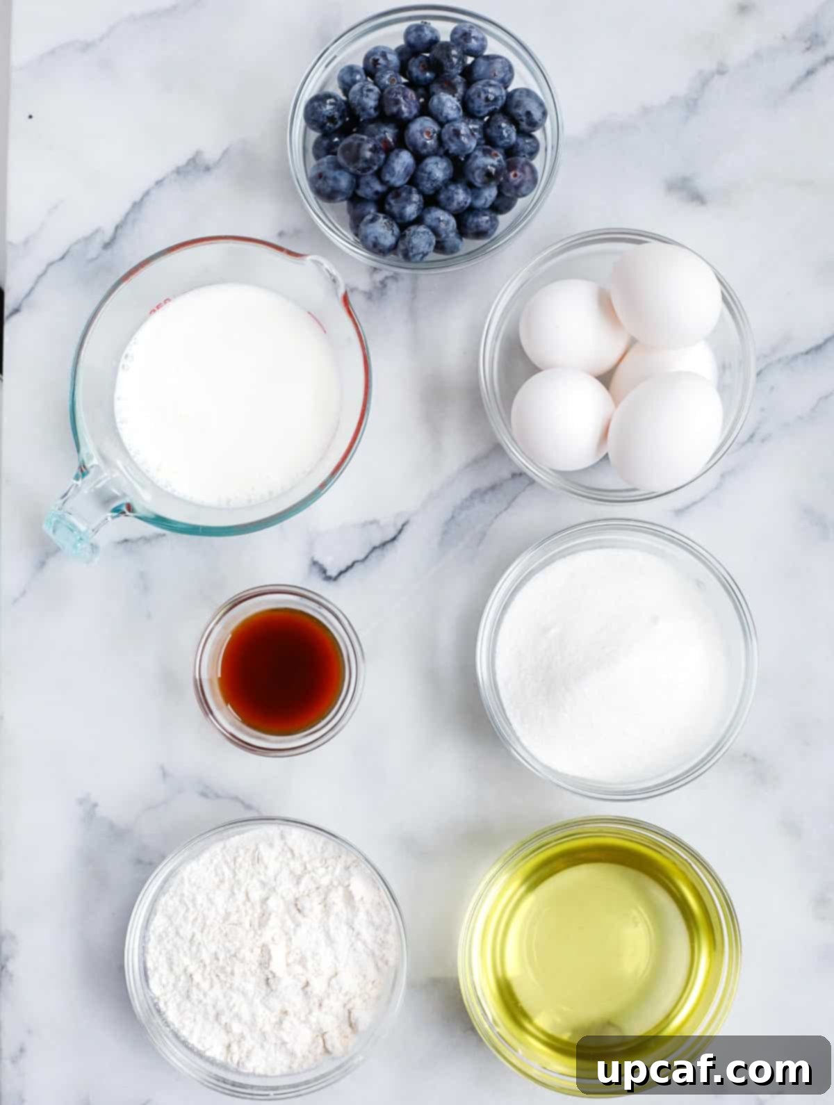 A flat lay photograph showcasing all the fresh ingredients needed for baking a delicious blueberry Bundt cake.