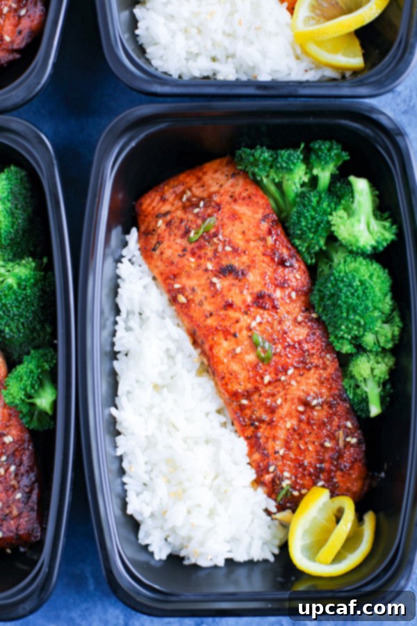 A perfectly portioned meal prep box featuring spicy honey garlic salmon, accompanied by fluffy rice and fresh steamed broccoli, ready for a healthy lunch.