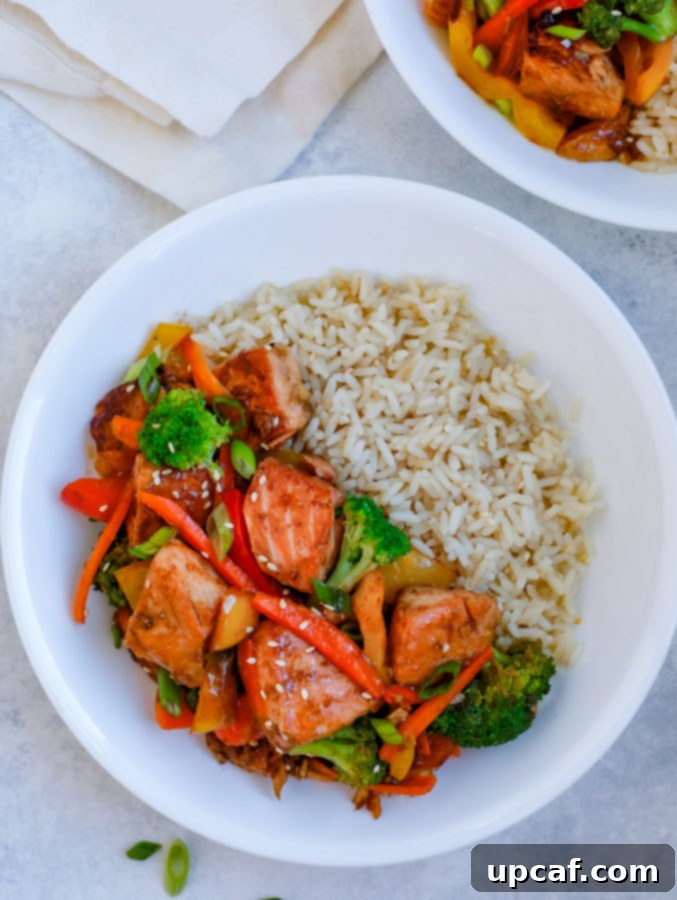 Glazed Teriyaki Salmon Medley 6 Teriyaki Salmon Stir Fry in a white bowl with rice on a white counter.