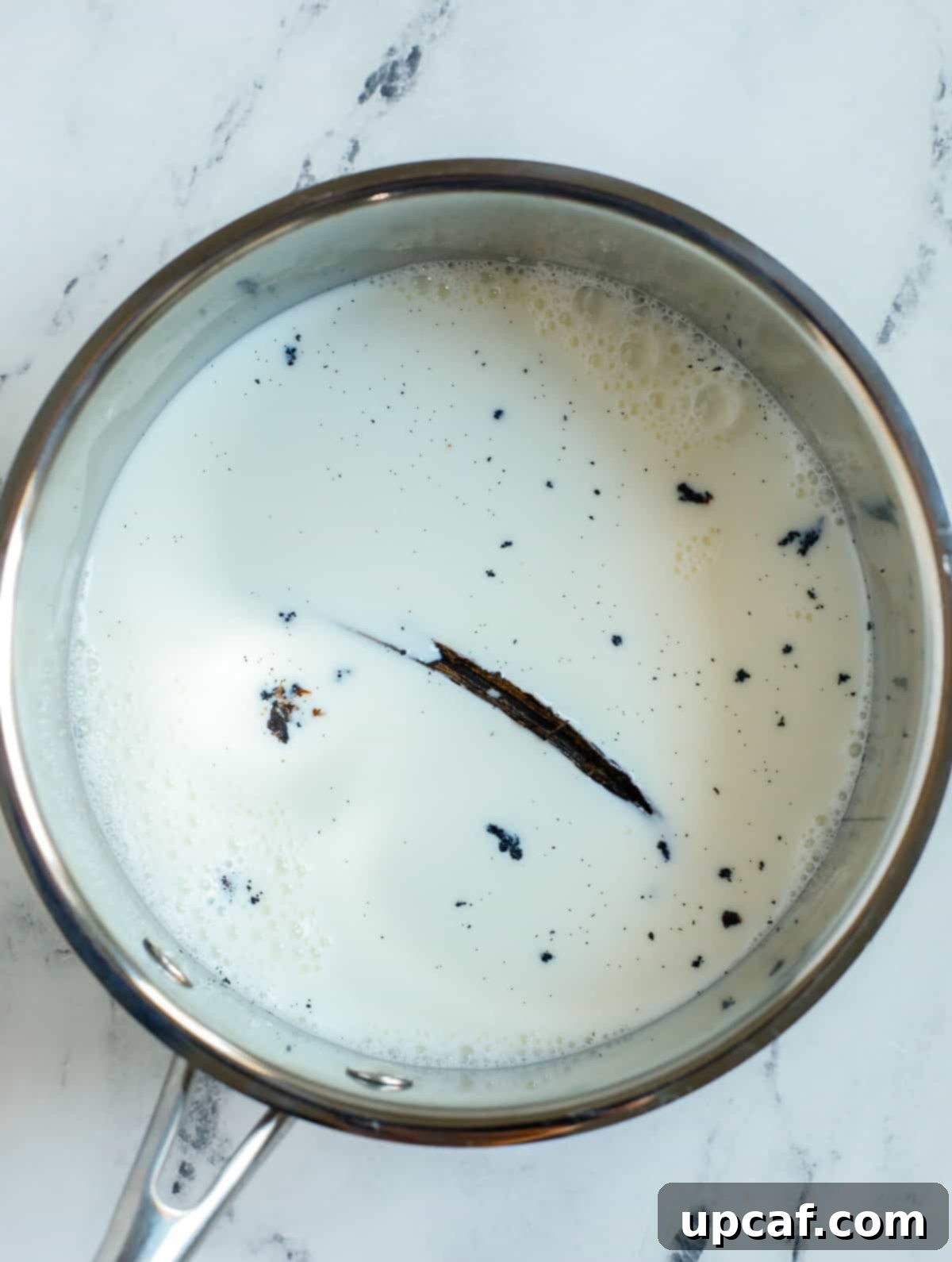 Effortless Pain Aux Raisins 4 milk in a pot with vanilla bean pod.