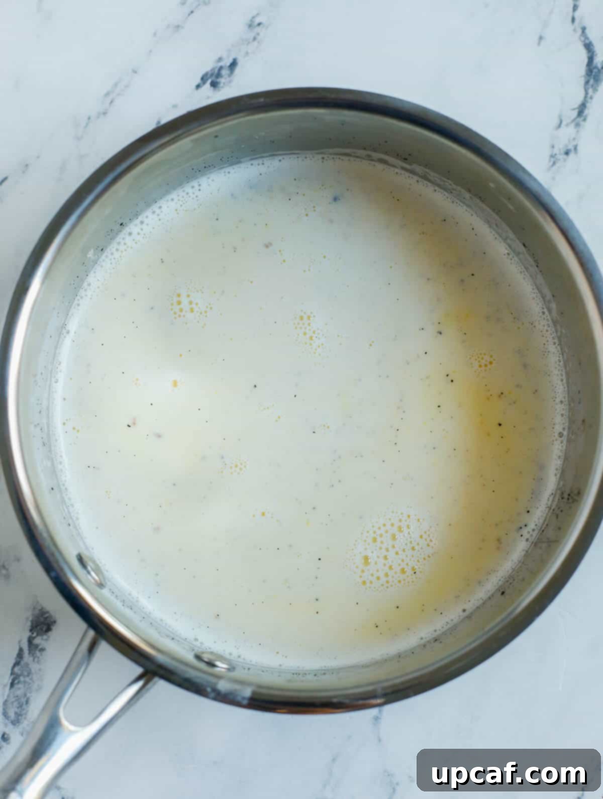 Effortless Pain Aux Raisins 6 milk and creme mixture in a pot.