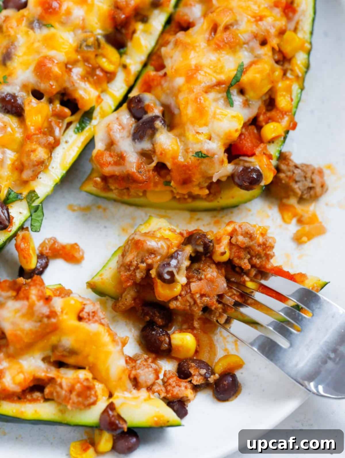 Loaded Zucchini Boats 6 A fork taking a delicious bite out of a baked stuffed zucchini boat.