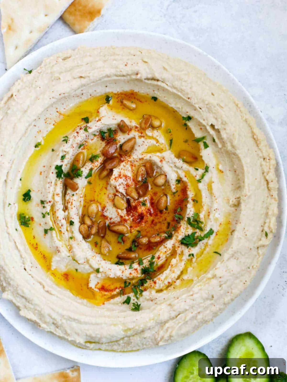 Effortlessly Delicious Lebanese Hummus 7 lebanese hummus in a plate, topped with olive oil, paprika, pine nuts