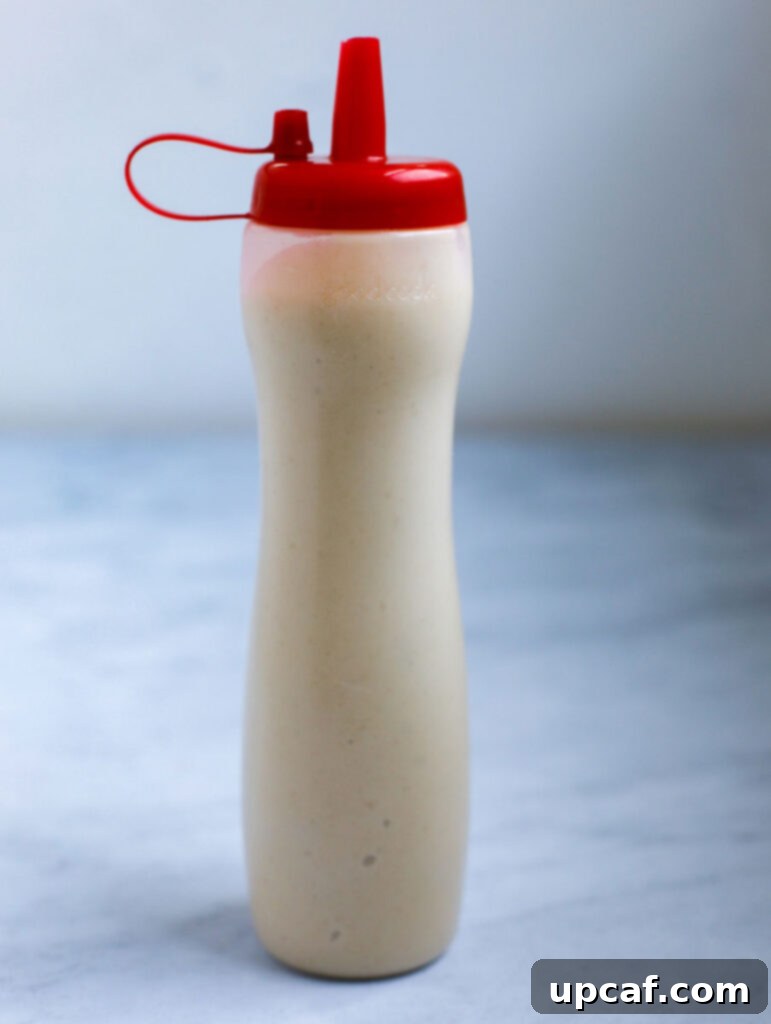 A clear image of smooth pancake batter neatly contained within a squeezable bottle, ready for precise piping onto a hot griddle or pan.