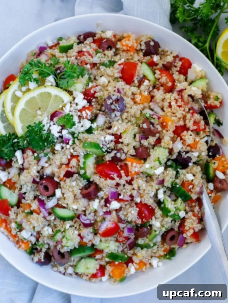 Mediterannean quinoa salad served in a elegant dish, garnished with fresh feta cheese, parsley, and vibrant lemon wedges