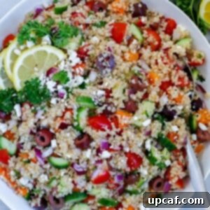 mediterranean quinoa salad served in a dish, dopped with feta cheese and lemon wedges