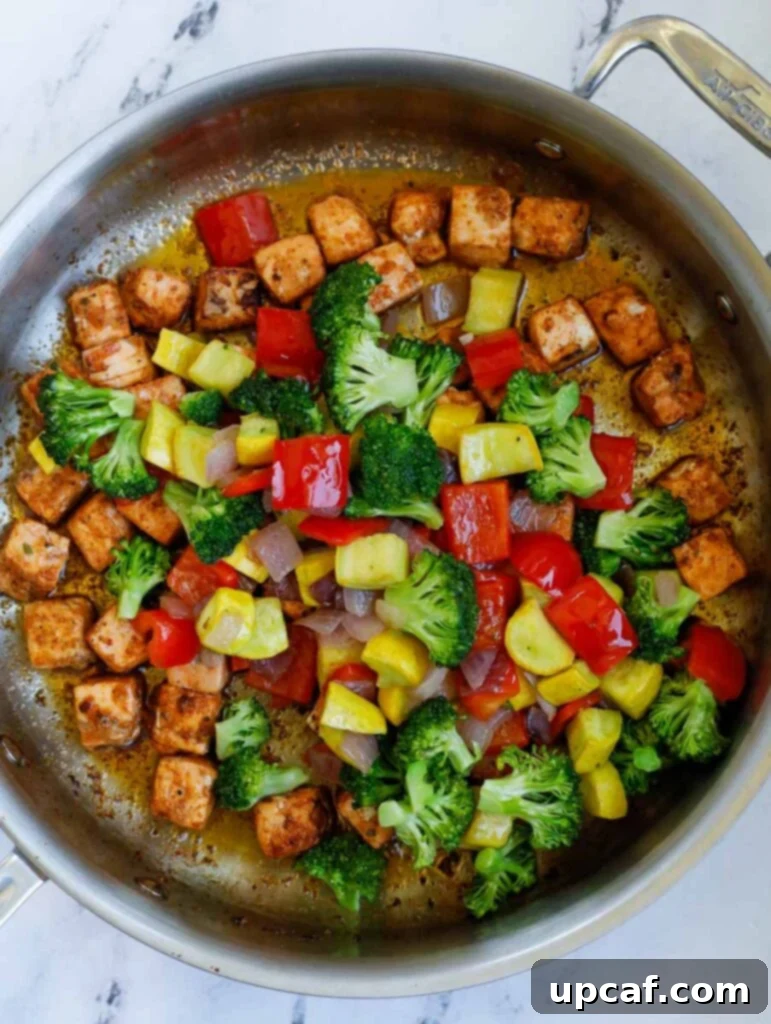 top down shot of salmon with vegetables in a skillet