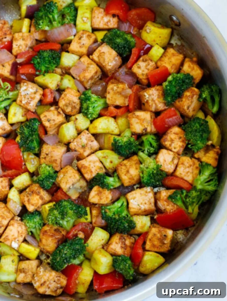 close up of salmon and veggies in a skillet