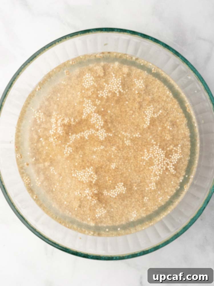 Rinsed quinoa soaking briefly in a bowl of water before cooking.