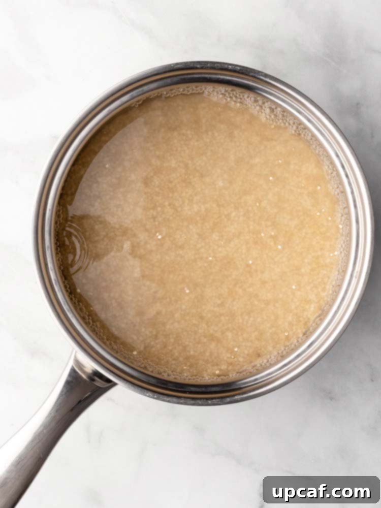 Quinoa simmering in a pot with water on the stove.