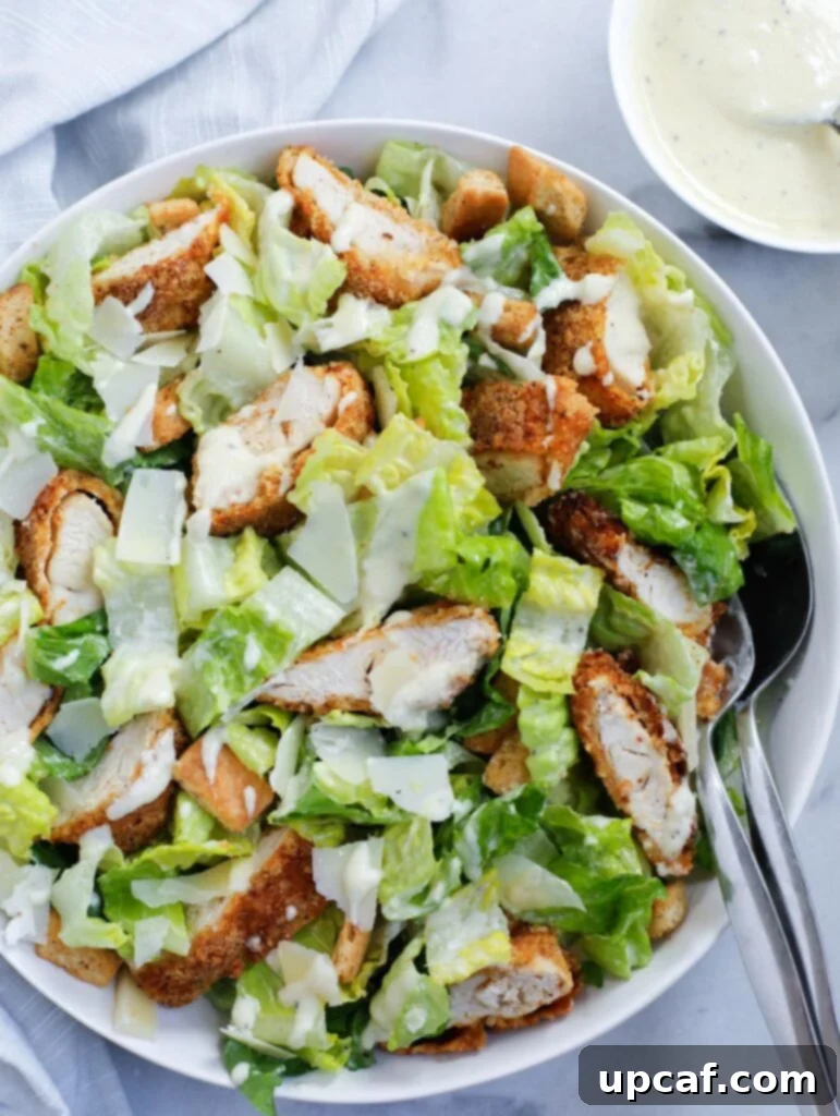 Crispy Chicken Caesar Salad served elegantly in a shallow white dish, ready to be enjoyed