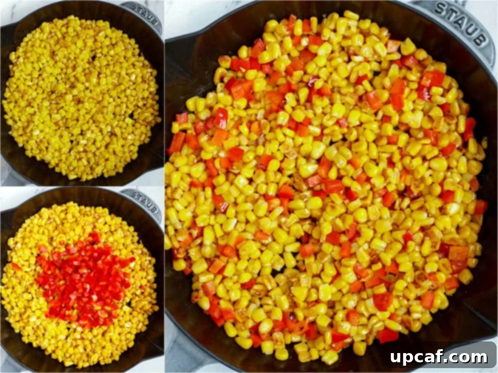 Close-up shot of corn kernels and red bell peppers cooking in a skillet on a stovetop, showing some charred marks.