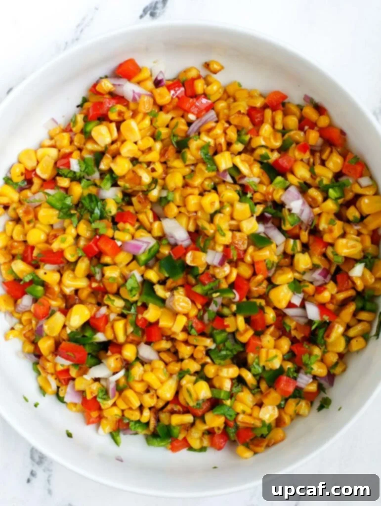 Overhead shot of the Mexican Street Corn Salad in a bowl, fully mixed with the dressing, before garnishing.