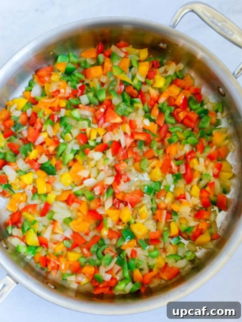 Fajita Fiesta Mac & Cheese 5 Cooking colorful bell peppers and onions in a large pan