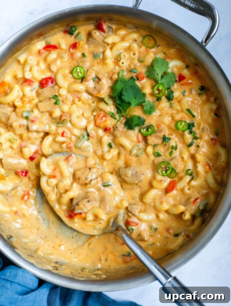 Fajita Fiesta Mac & Cheese 9 Spoon scooping creamy mac and cheese from a pot