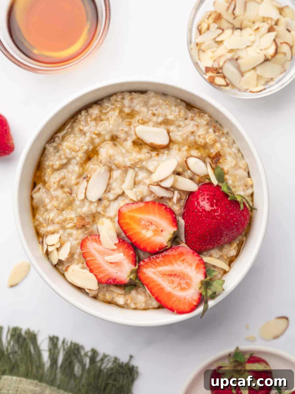 Instant pot steel cut oats in a bowl topped with strawberries and almonds.
