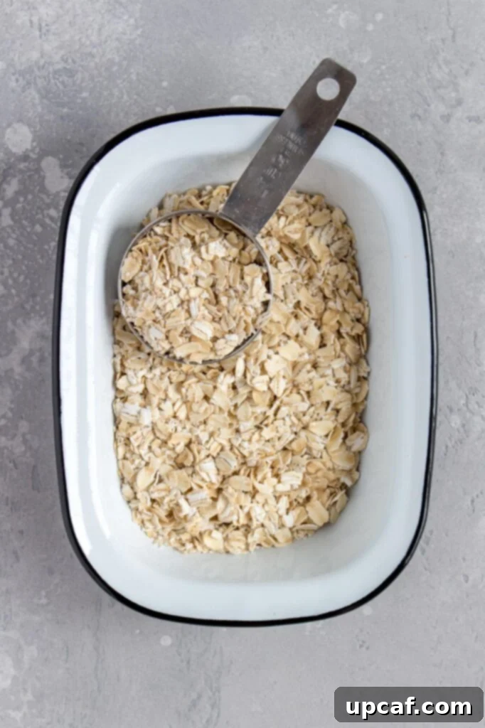 A bowl of whole rolled oats, ready to be processed into flour.