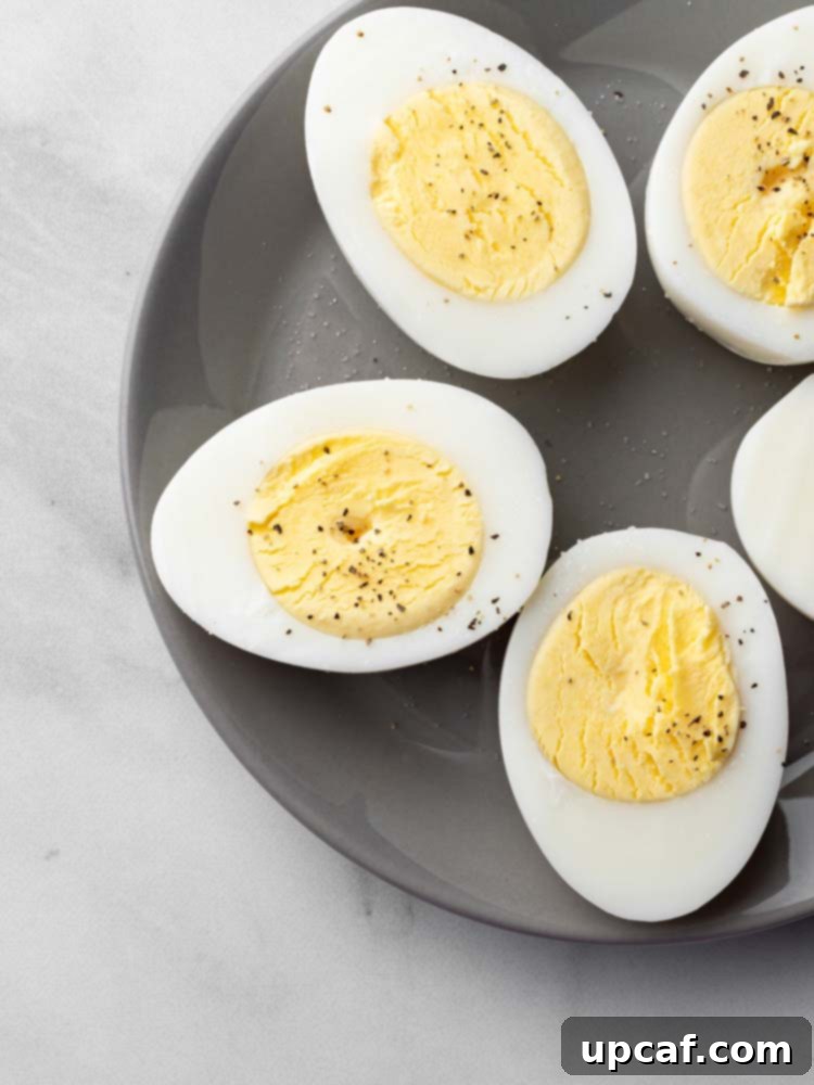 Two halves of a hard-boiled egg, beautifully seasoned with salt and freshly ground pepper.