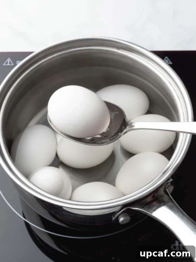 A close-up of an egg being carefully lifted out of simmering water.