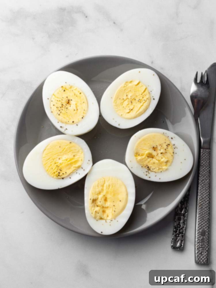 Perfectly hard-boiled eggs, sliced in half, with creamy yolks seasoned with salt and pepper.