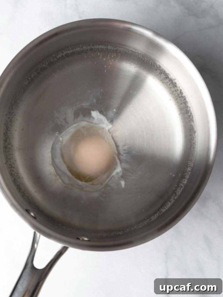 A poached egg nearing completion in hot water