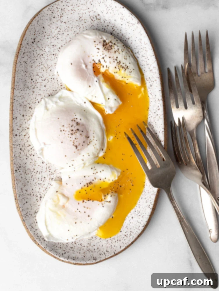 Three perfectly poached eggs on a plate with runny yolks