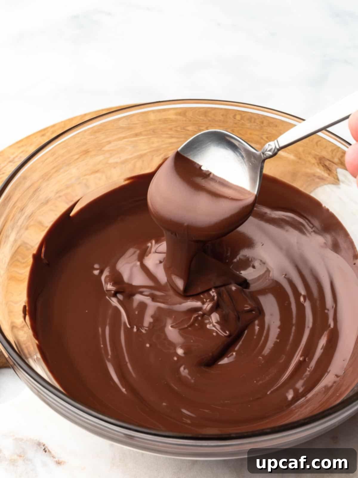 A bowl of perfectly melted chocolate, ready for use.