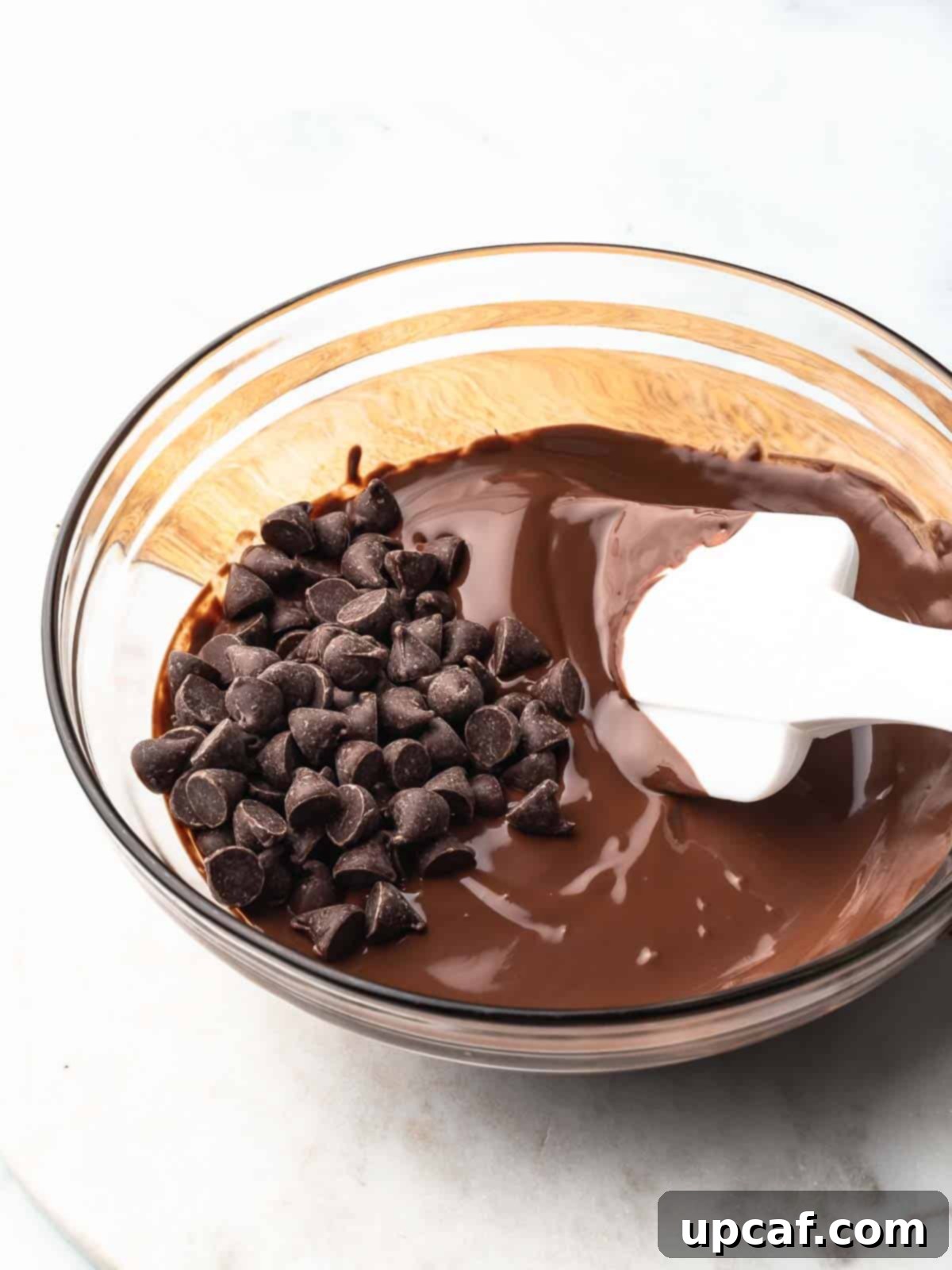 Chocolate chips and partially melted chocolate in a microwave-safe bowl.