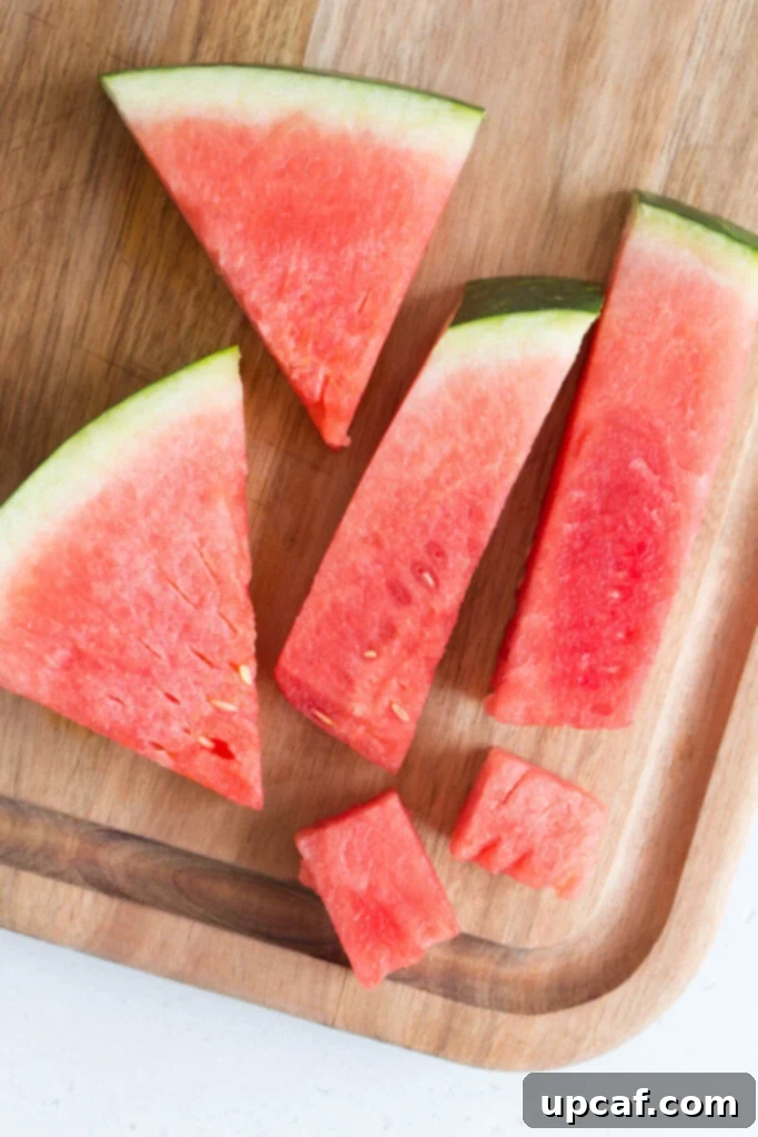 Various cuts of watermelon: wedges, sticks, and cubes arranged on a white surface.