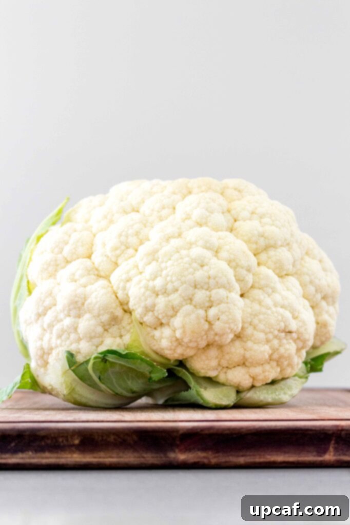 Whole, fresh cauliflower with green leaves