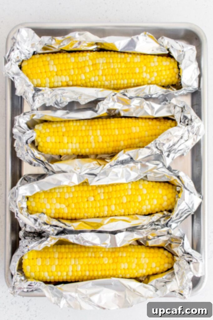 Cooking Corn to Perfection 8 Corn wrapped in foil with butter, ready for oven roasting