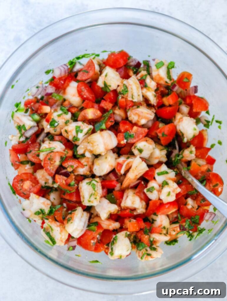 Zesty Shrimp Avocado Boats 5 A top-down view of a vibrant shrimp and vegetable mixture being tossed in a bowl, showcasing the fresh ingredients for the avocado filling.