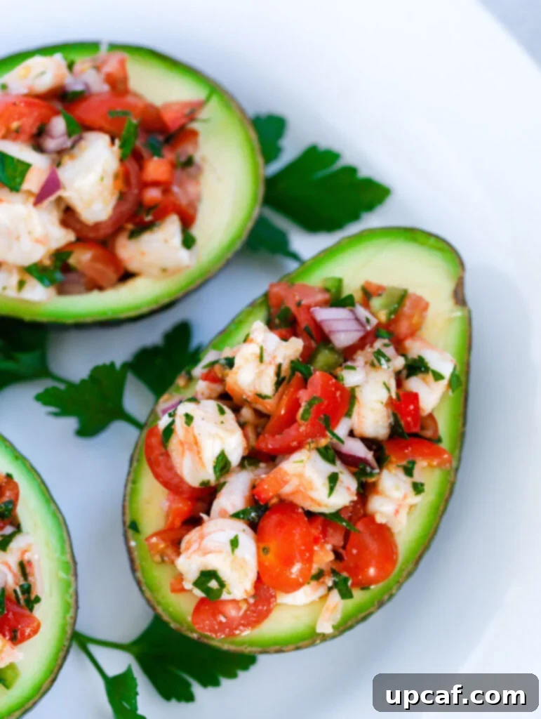 Zesty Shrimp Avocado Boats 6 A single Healthy Shrimp Stuffed Avocado half, garnished with fresh herbs, resting on a clean white plate, ready to be enjoyed.